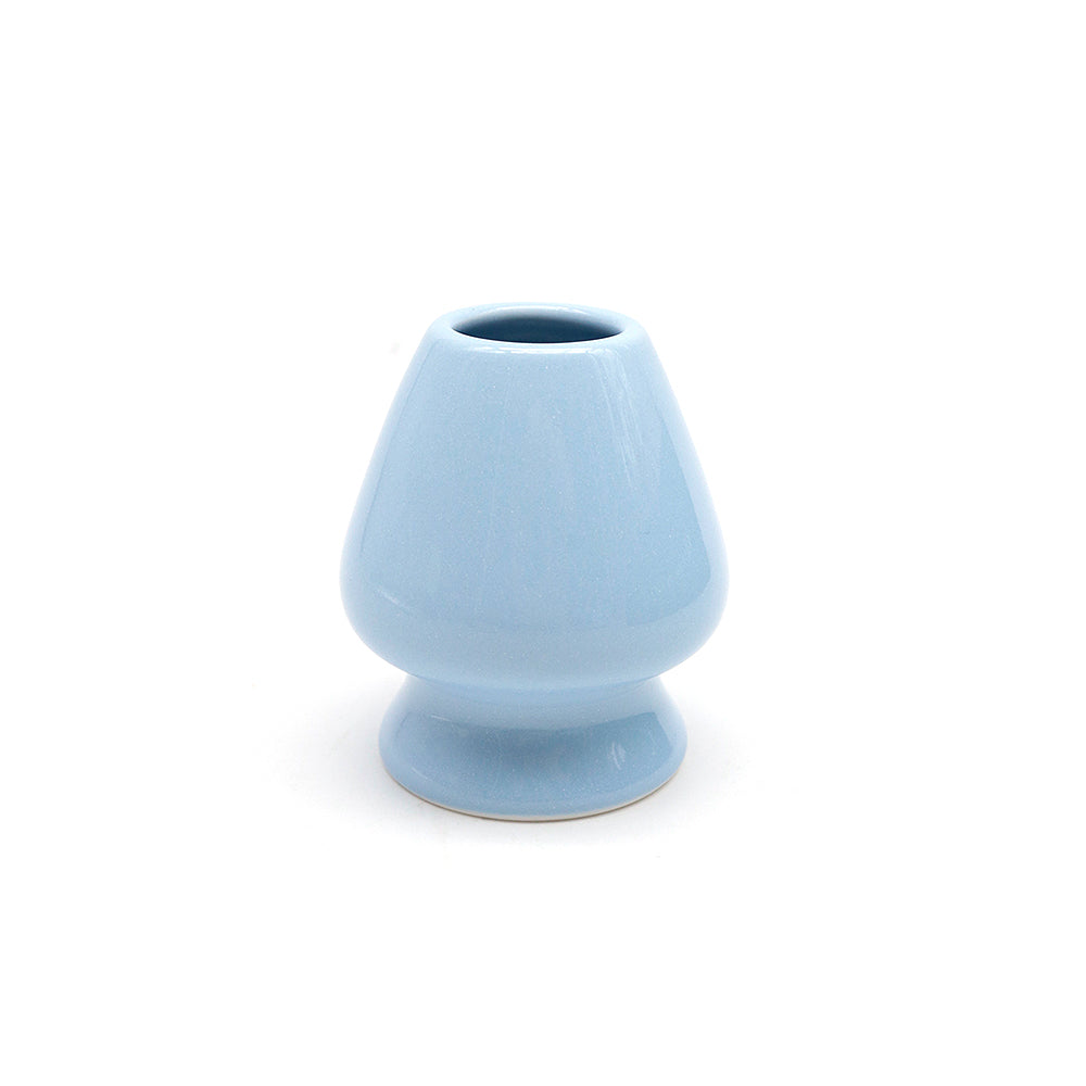 Light blue ceramic whisk stand on a white background