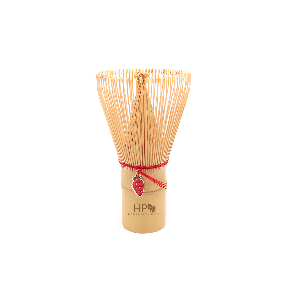 Bamboo whisk with red string strawberry ornament and logo on a white background