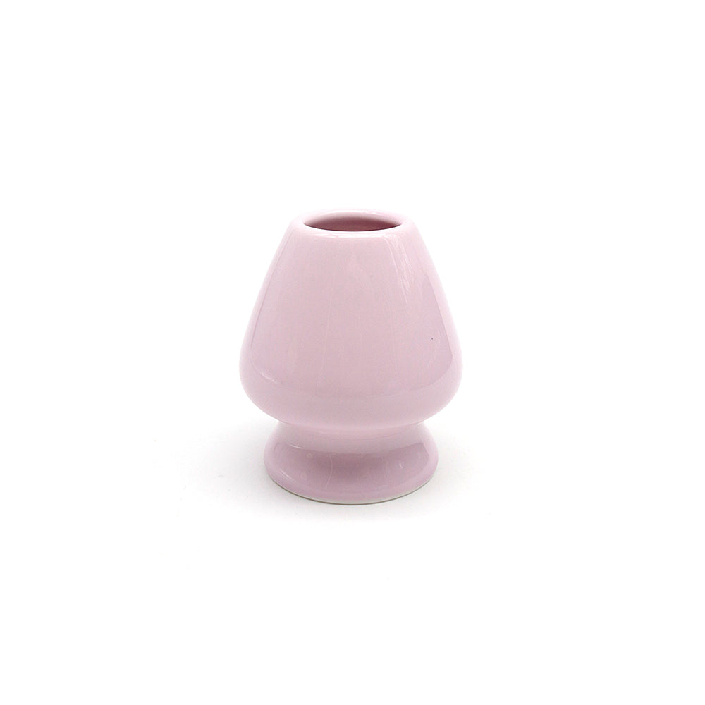 Pink ceramic whisk stand on a white background