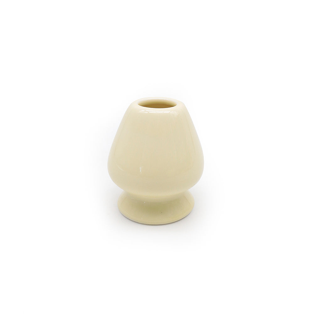 cream yellow ceramic whisk stand on a white background